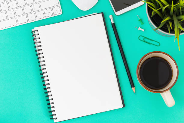 istock Top view, empty notebook and office supplies on the desk. 1016547580