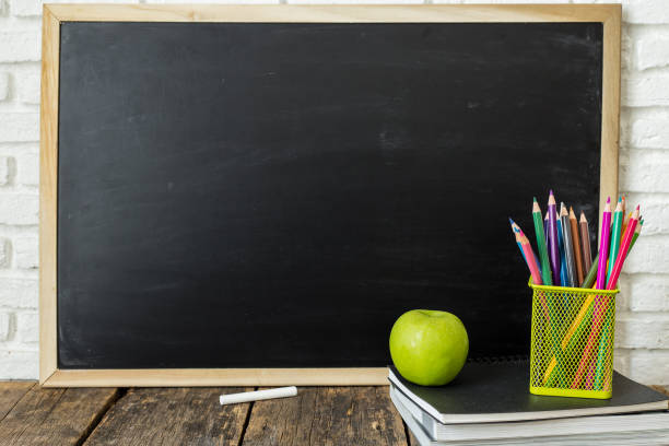 istock Books and chalkboard on wooden background 1016547738