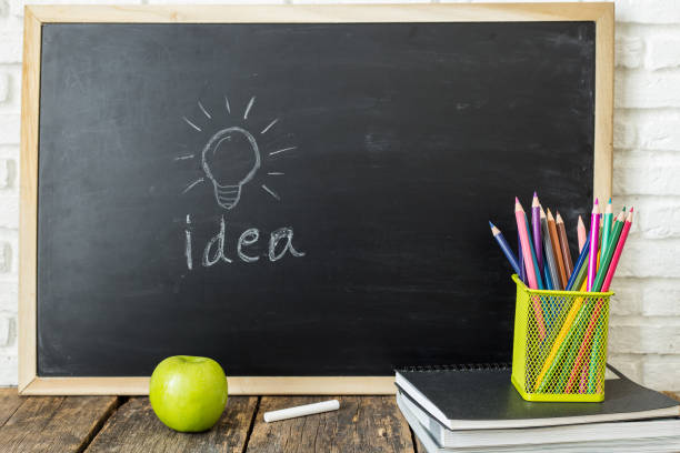 istock Books and chalkboard on wooden background 1016547752