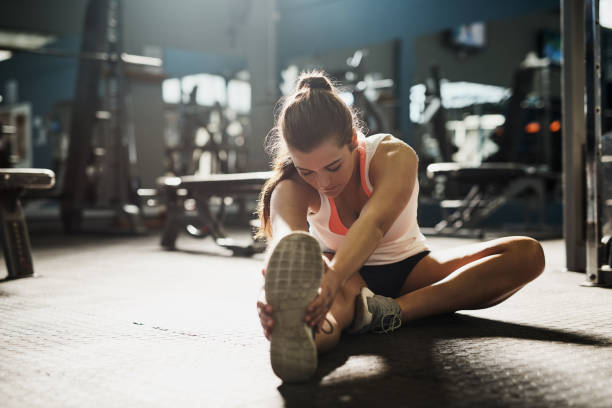 Stretch beyond your limits Shot of a young woman doing stretch exercises at the gym touching toes stock pictures, royalty-free photos & images