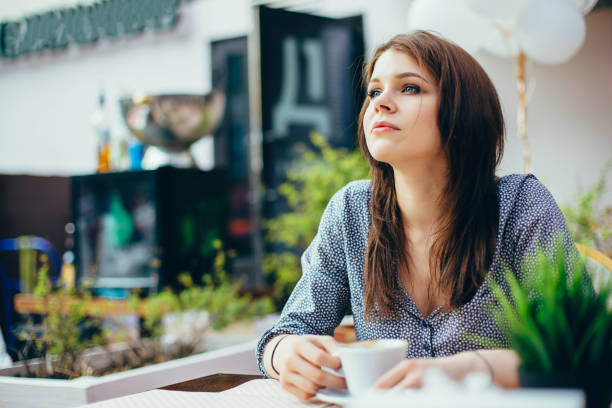 istock Young attractive girl drinks coffee in a city cafe. 1016556080