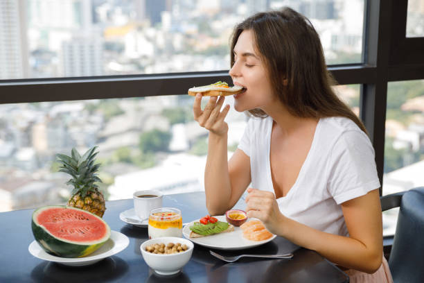 istock Young woman eating breakfast at morning 1016556196