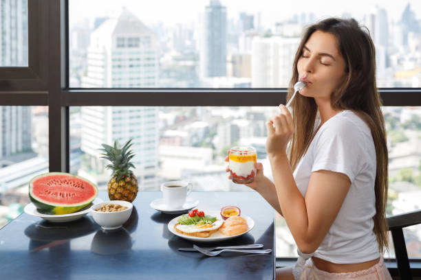 istock Young woman eating breakfast at morning 1016556288