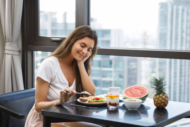 istock Young woman eating breakfast at morning 1016556322