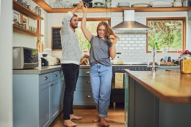 The spark will never fade in our relationship Shot of a young couple dancing in their kitchen fade in stock pictures, royalty-free photos & images