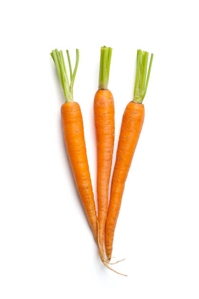 Three fresh young carrots with a cut tops isolated on white background. stock photo