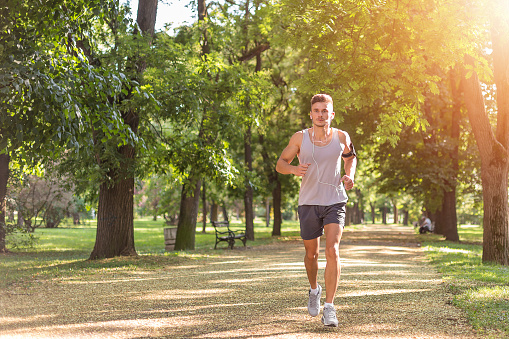 Sport fitness model training outdoor for marathon. City fitness. Running in the park.