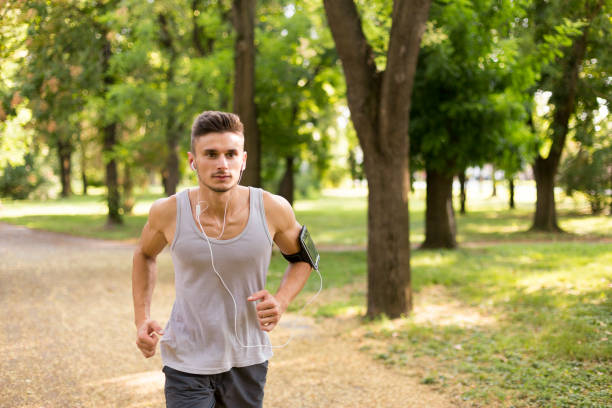 istock Young male jogging in the park 1016592616