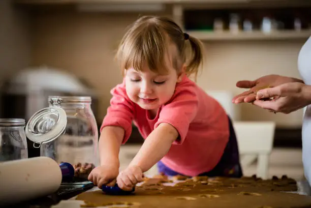 Mother and child baking together cookies at home