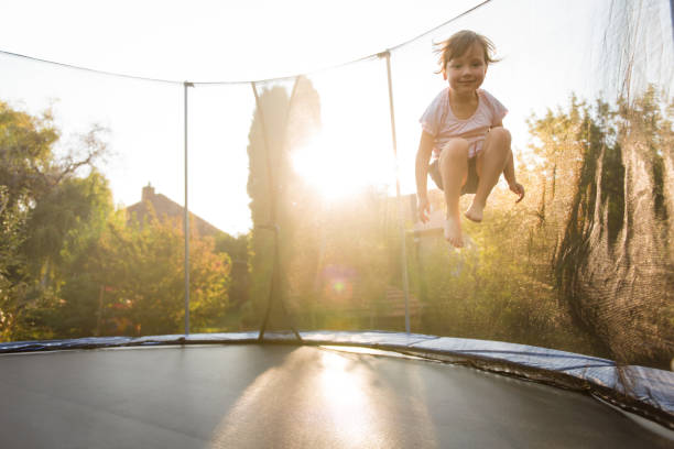 istock Girl child playing on trampoline in backyard 1016601900