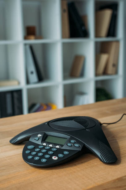 istock speakerphone on wooden table at office with blurred bookshelves on background 1016601962