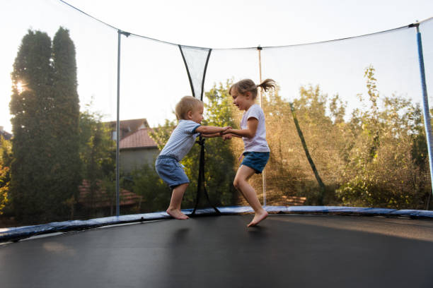 Little kids bouncing off the trampoline taut stock photo