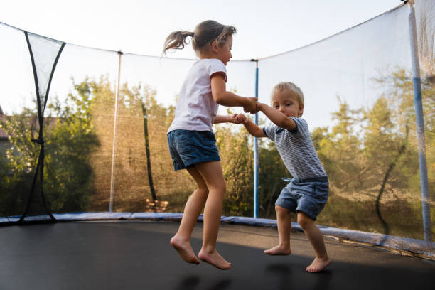 istock Adorable siblings bouncing together on trampoline 1016602058