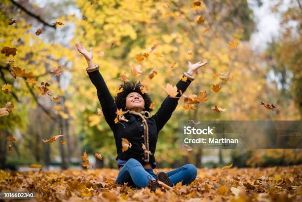 Joyous Teen Playing With Dry Maple Leaves Stock Photo - Download Image Now - Autumn, Women, Leaf