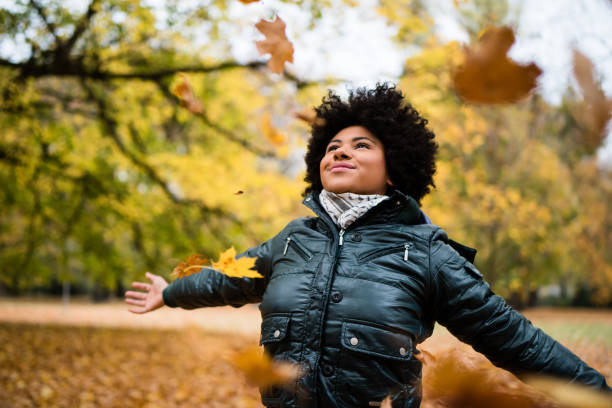 istock Teenager with arms widespread in fall park 1016602446