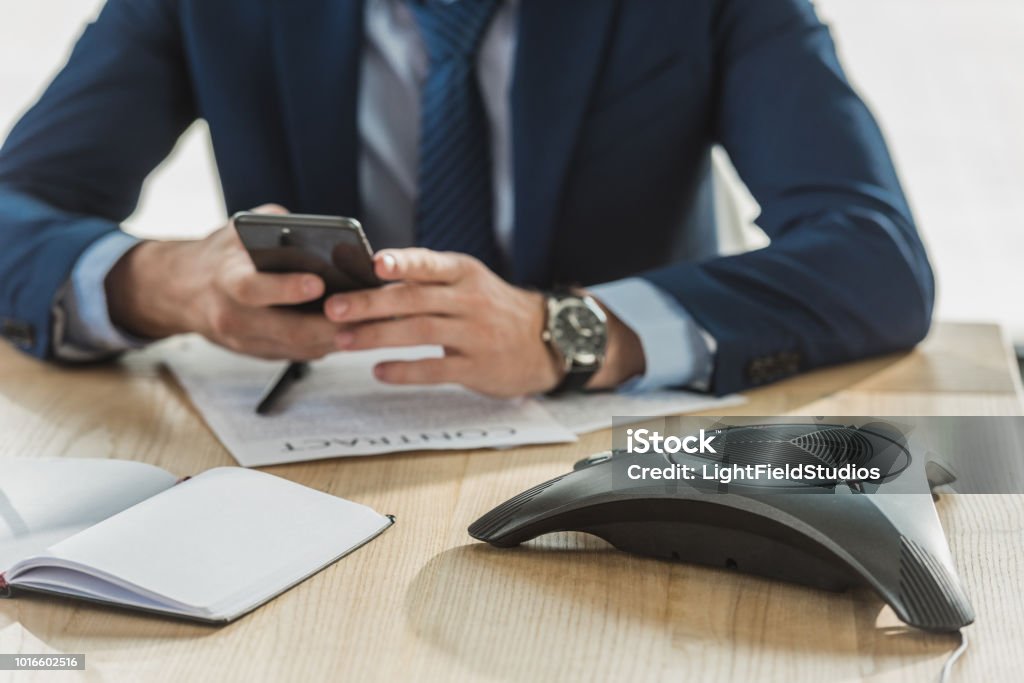 cropped shot of businessman using smartphone at workplace Adult Stock Photo