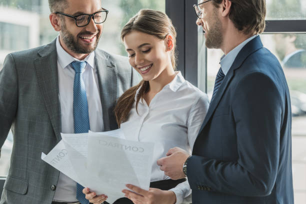 istock happy young business people discussing documents together at office 1016605582