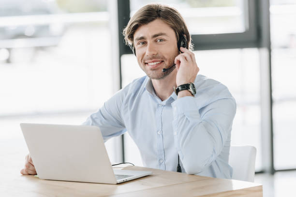 istock smiling call center worker with laptop looking at camera while sitting at workplace 1016606068