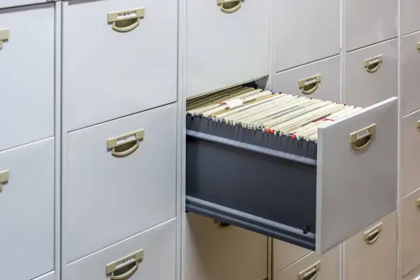 Photo of File cabinet with a wide open drawer full of files