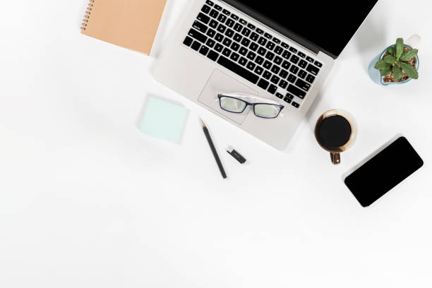 istock Office table with laptop computer, smartphone, pen, notebook and coffee on isolated pure white background / Laptop and tablet mockup concept. (Selective Focus) 1016614672