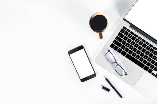istock Office table with laptop computer, smartphone, pen, notebook and coffee on isolated pure white background / Laptop and tablet mockup concept. (Selective Focus) 1016614680