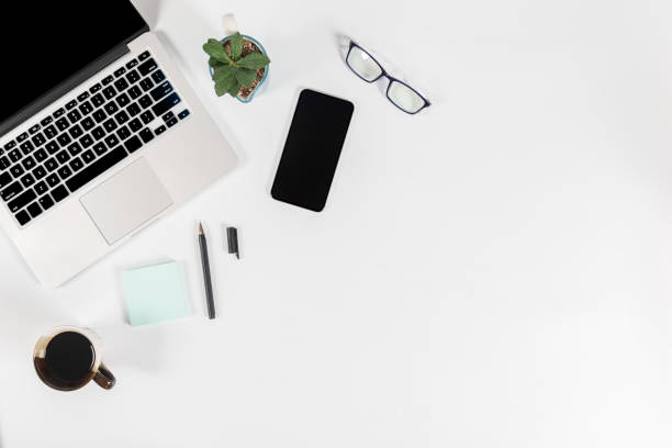 istock Office table with laptop computer, smartphone, pen, notebook and coffee on isolated pure white background / Laptop and tablet mockup concept. (Selective Focus) 1016614692