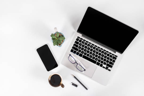 istock Office table with laptop computer, smartphone, pen, notebook and coffee on isolated pure white background / Laptop and tablet mockup concept. (Selective Focus) 1016614704