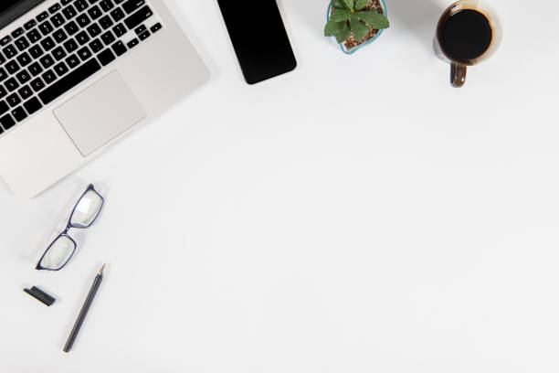 istock Office table with laptop computer, smartphone, pen, notebook and coffee on isolated pure white background / Laptop and tablet mockup concept. (Selective Focus) 1016615040