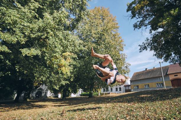 Boy practicing free runnuing Boy practicing free runnuing in public park and jumping upside down. handspring stock pictures, royalty-free photos & images