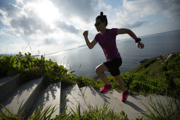 istock Woman runner running up on seaside mountain stairs 1016635502