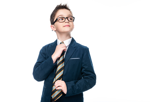 schoolboy in businessman suit tying necktie isolated on white