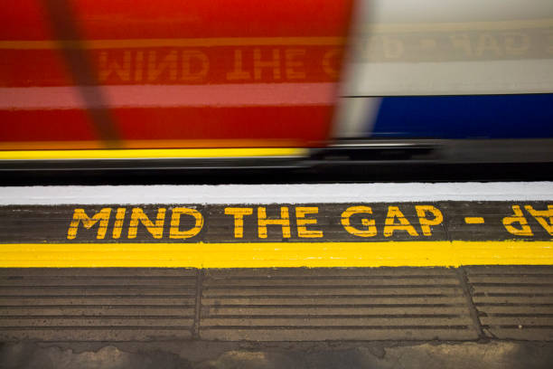 Mind the gap sign on London underground Yellow MIND THE GAP sign at the London subway platform. Turist atraction. gap toothed stock pictures, royalty-free photos & images