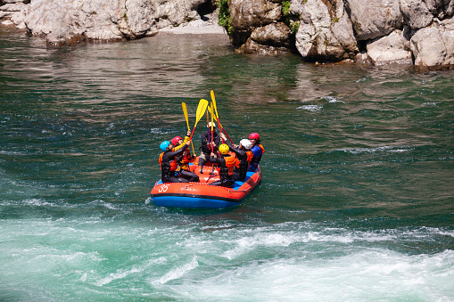 A small group of people celebrating success while white water river rafting in Japan