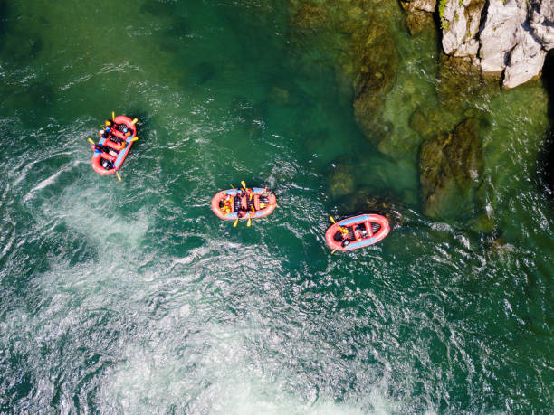 aerial view of a group of men and women in multiple boats white water river rafting - white water rafting rafting rapid river imagens e fotografias de stock