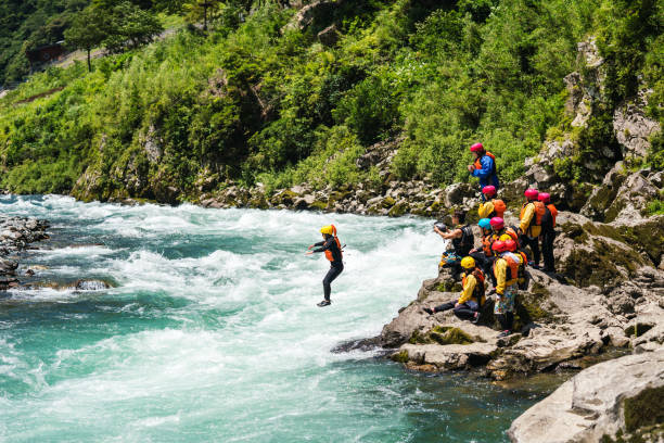 istock Man jumping into a river with a life jacket on while on an adventure tour 1016648004