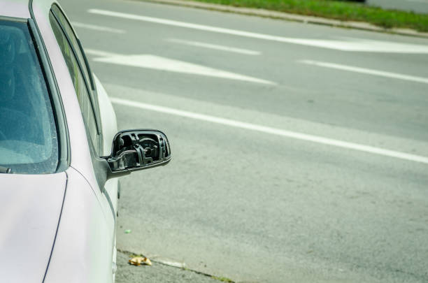 istock Broken and damaged side mirror on the car doors with remaining wires holding plastic frame without glass 1016648038