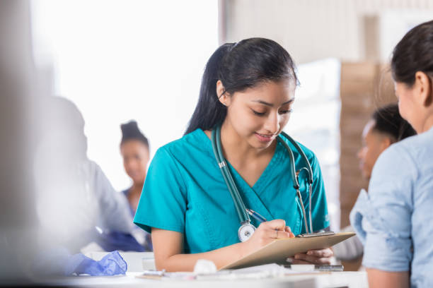 istock Young nurse concentrates as she interviews patient 1016651214