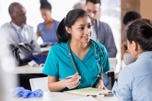 istock Young nurse asks questions as she fills out intake paperwork 1016651260