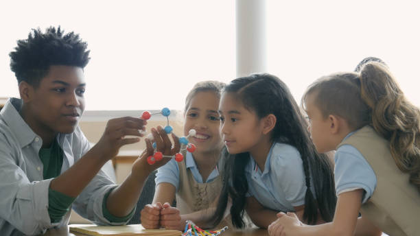 istock Teenage boy shows molecular model to elementary students 1016651478