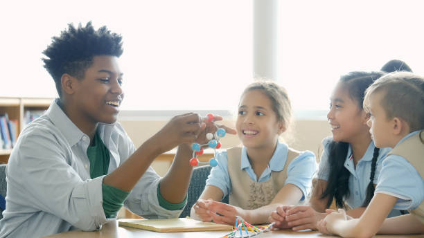 istock Teen boy enjoys mentoring elementary students in science 1016651516