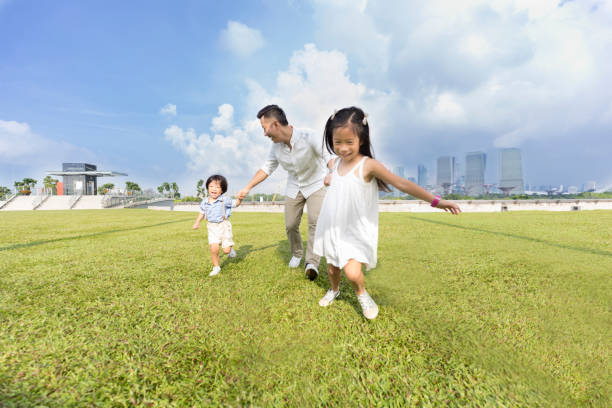 istock Children run with dad in city park 1016651812
