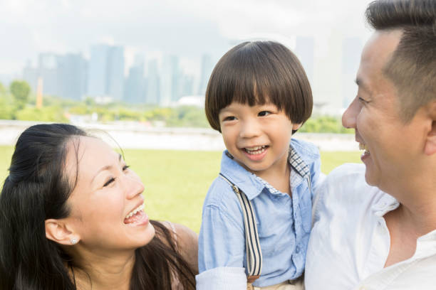 Happy mid adult couple enjoy time with their preschool age son in a city park.