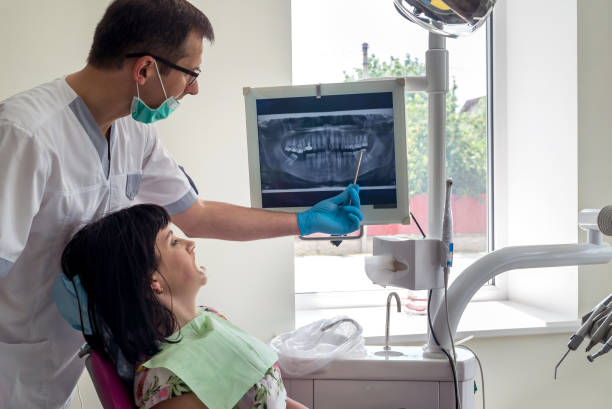 istock Dentist and patient looking at x-ray of teeth on screen 1016654158