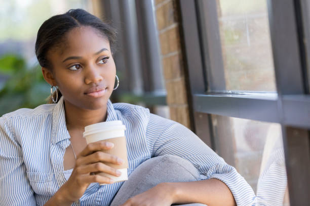 istock Reflective woman looks through window 1016654676