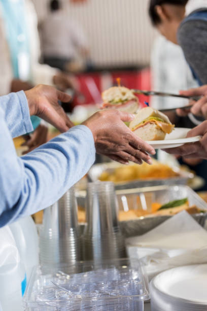 istock Unrecognizable volunteer serving meal in soup kitchen 1016654914
