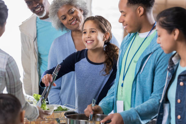 istock Cheerful elementary age girl volunteers in soup kitchen 1016654938