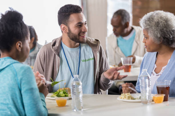 istock Volunteer has lunch with people in soup kitchen 1016654954