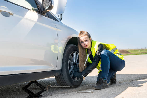 istock Woman changing damaged wheel and fixing it 1016655202
