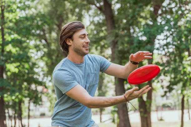 istock handsome man catching frisbee disk in park 1016658848