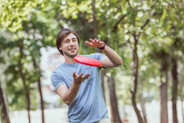 istock handsome man catching frisbee disk in park 1016658880